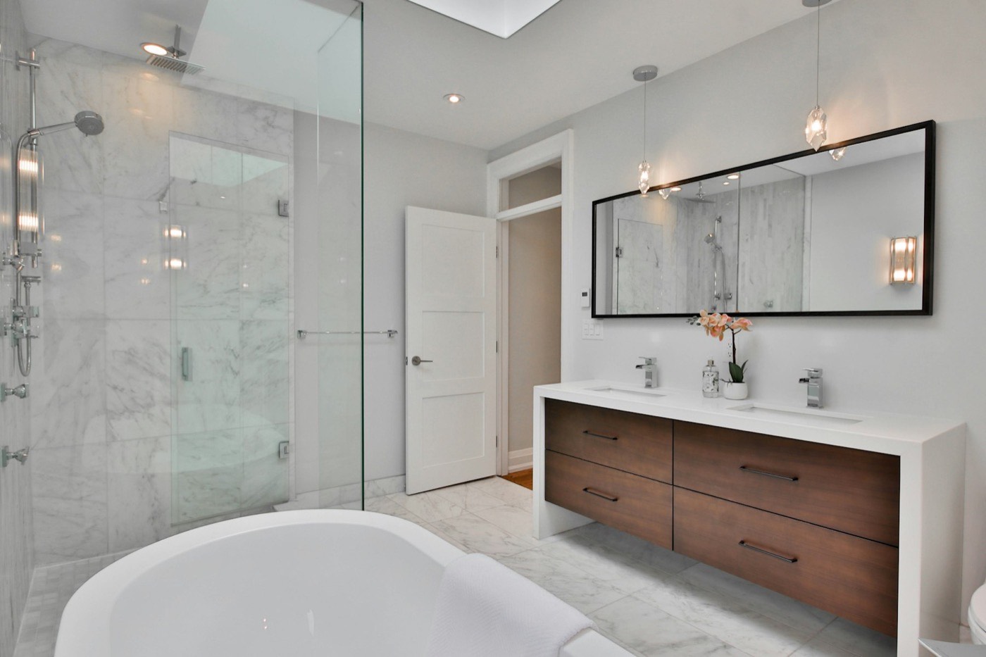 Renovated bathroom with freestanding bath and walk-in shower.