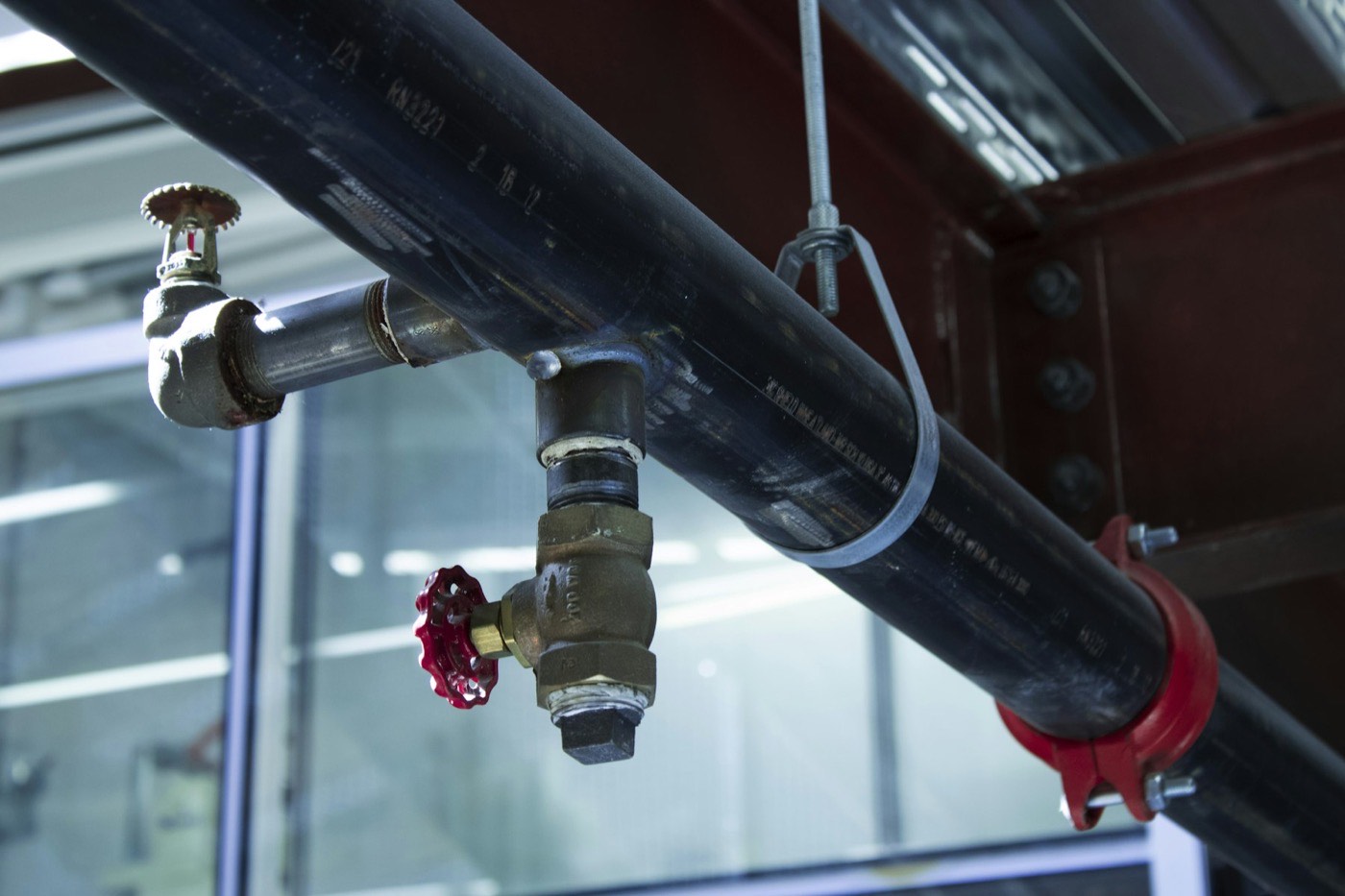 Commercial pipework and shut-off valve in a plant room.