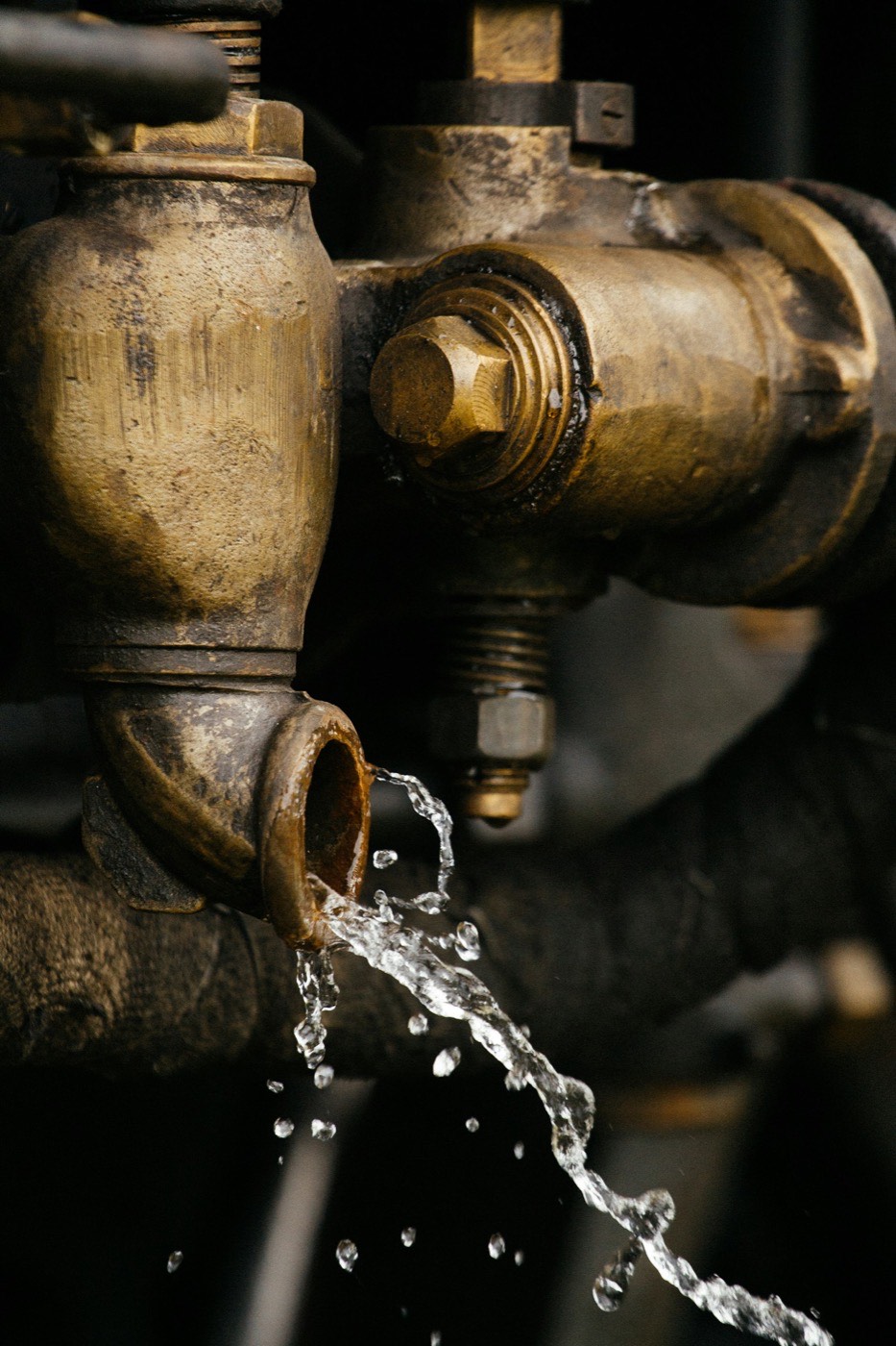 Water dripping from a corroded brass pipe fitting.